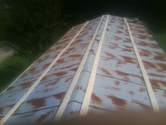 Rusted metal roof panels with new wood purlins before replacement — Storm Damage Roof Repair in Hallsboro by Roofing Brothers