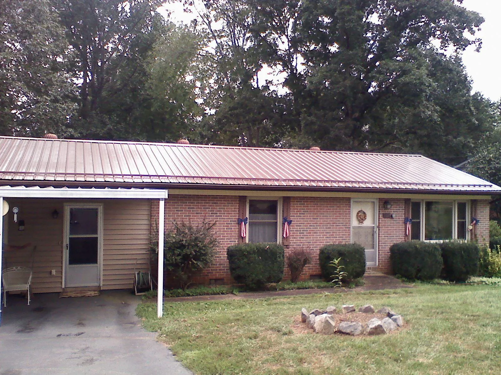 Bronze metal roof and carport on a brick ranch home — Roof Repair work by our crew in Hallsboro